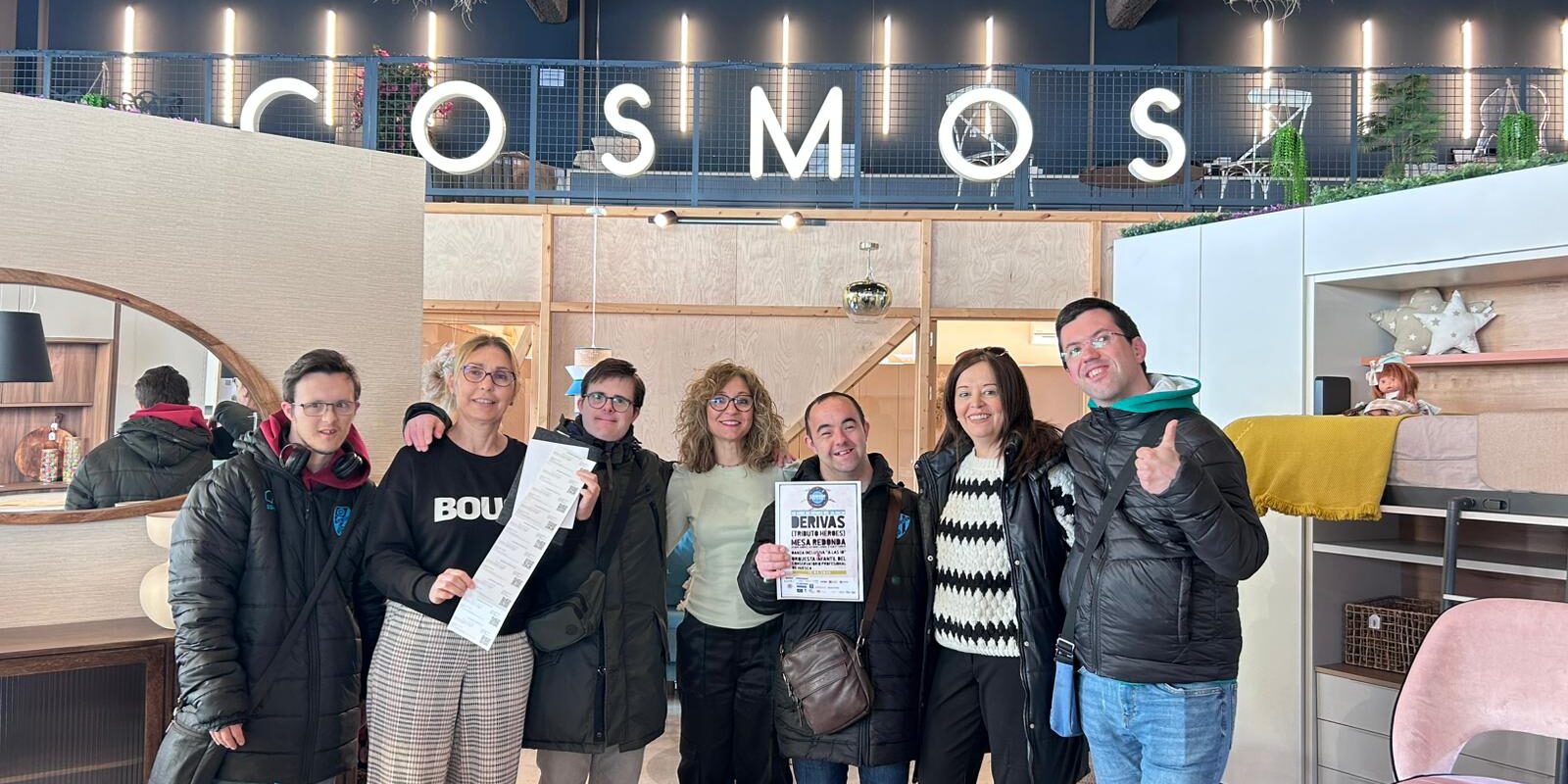 Nuria Grau de Cosmos Castellar junto a los chicos de la Asociación Down Huesca durante la entrega de la invitación al Cosmos Festival 2025 en Huesca